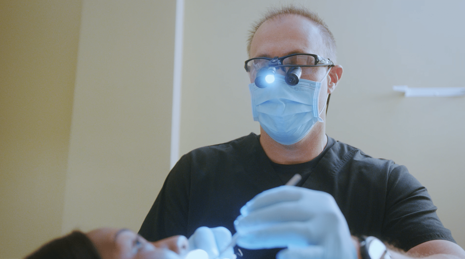 Dentist checking out patient teeth in operatory