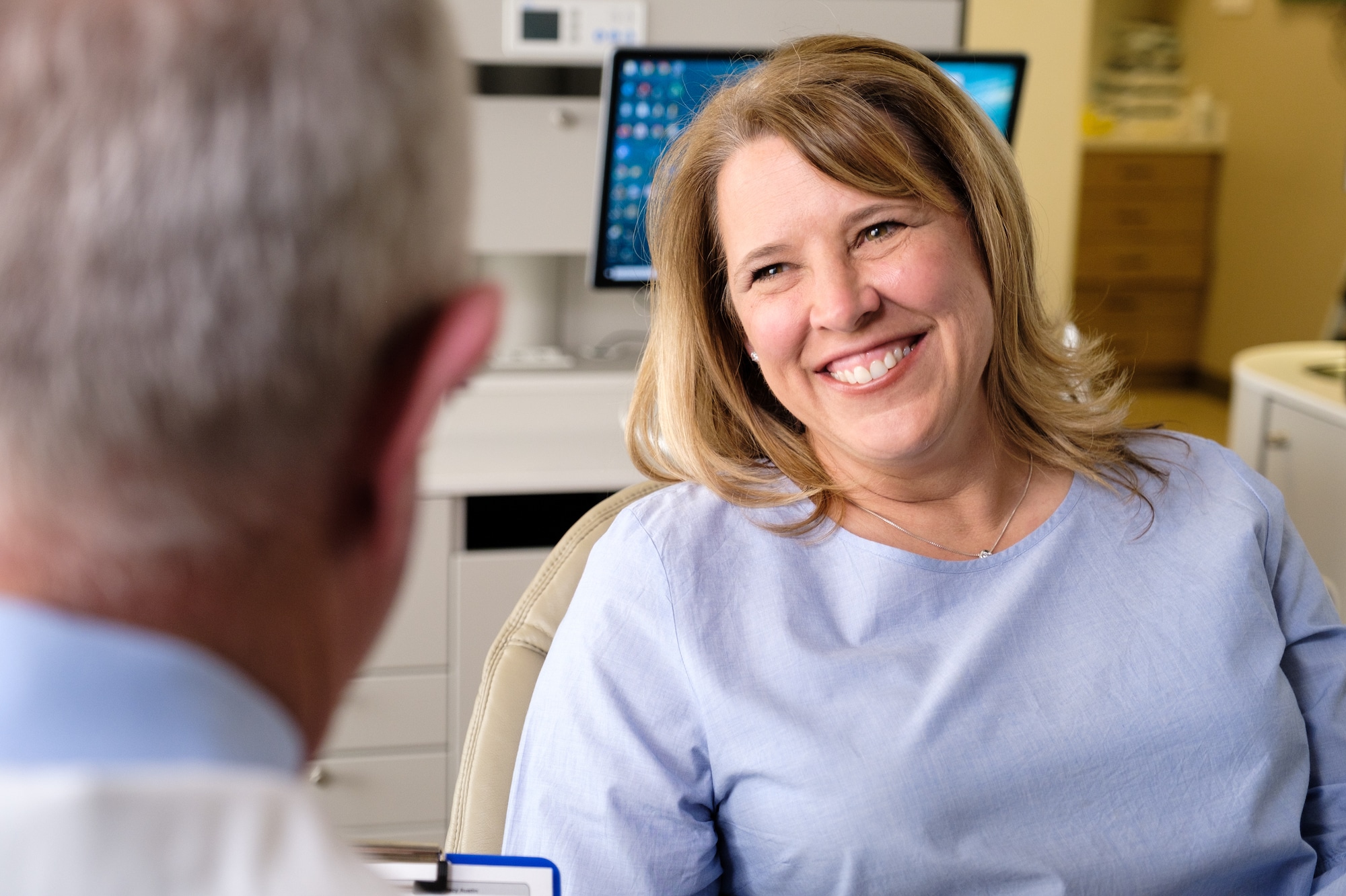 Doctor talking to patient in chair