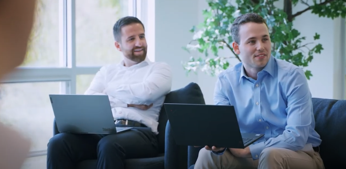 Two men sitting with laptops