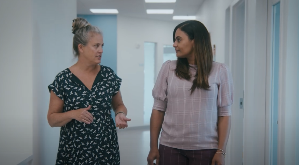 Two women walking in hallway